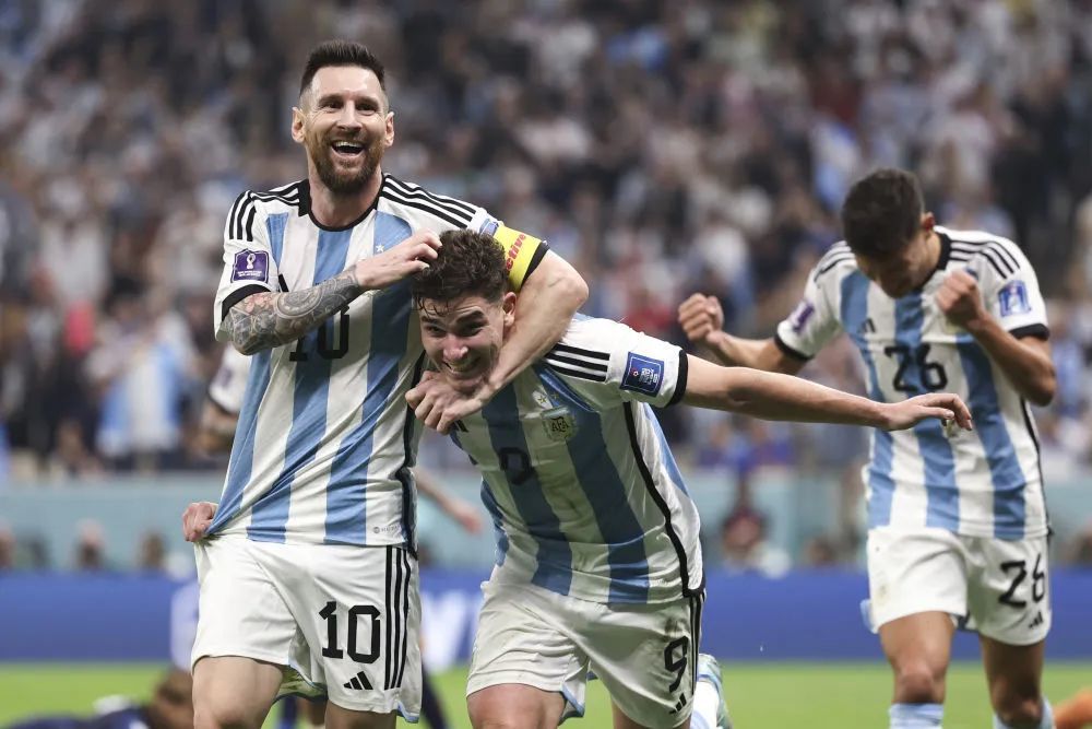 12月13日，阿根廷队球员阿尔瓦雷斯（前右）在比赛中进球后与队友梅西（前左）庆祝。新华社记者徐子鉴摄