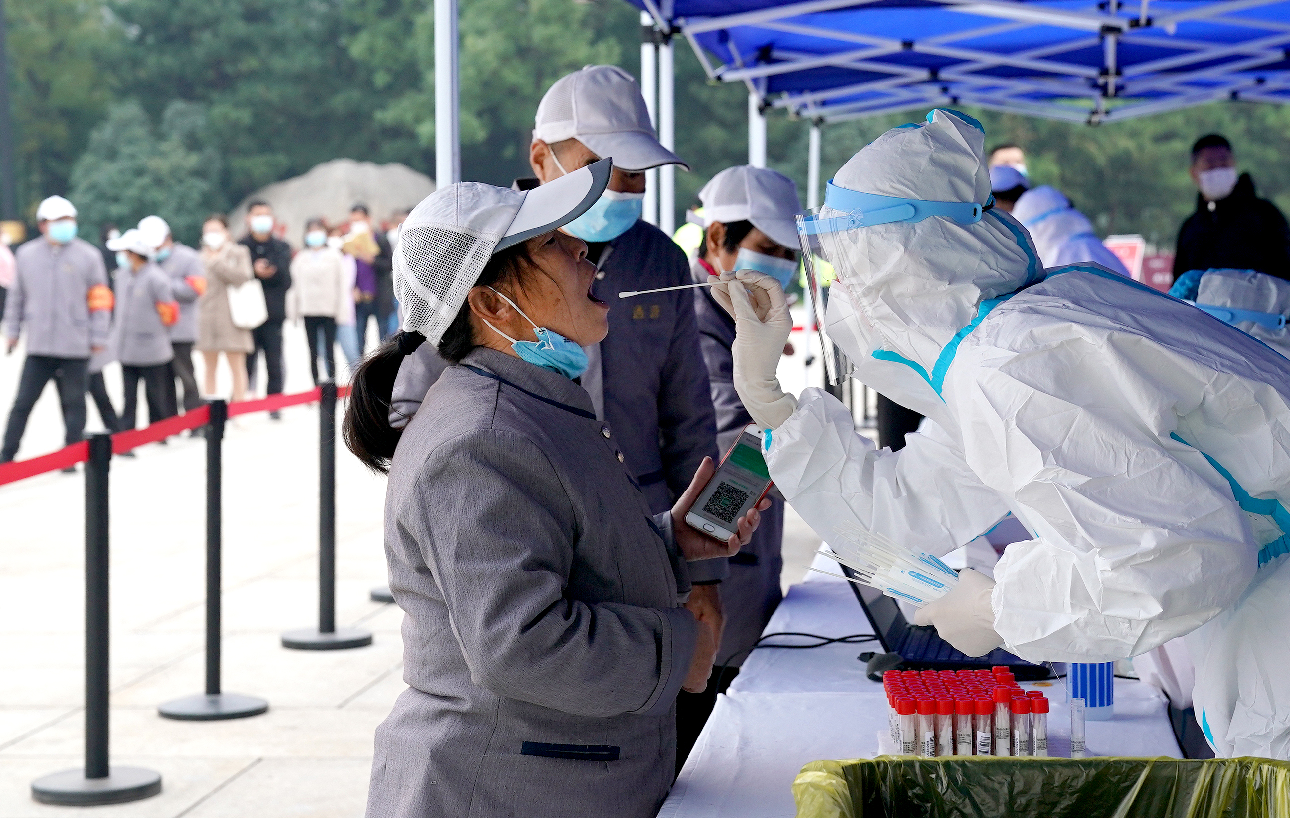 10月19日,市民在西安市曲江池遗址公园外一核酸检测点进行核酸检测