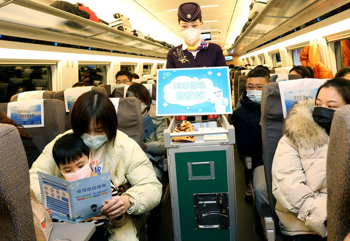 1月16日，乘务员在上海虹桥开往汉口的G1724次列车上向旅客分发防疫宣传册。新华社记者 陈飞 摄