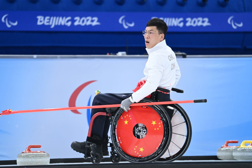 中国队选手陈建新在轮椅冰壶循环赛中操作轮椅在比赛中行进(3月10日