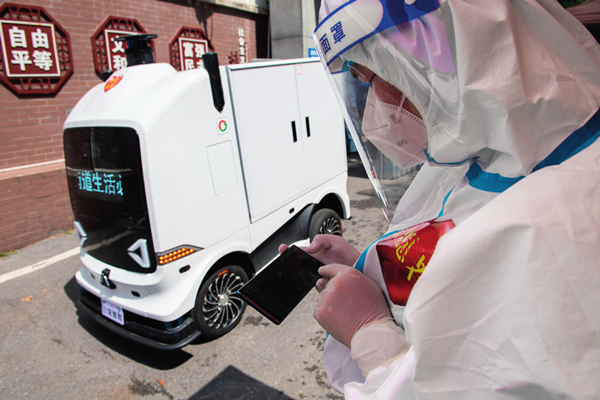 2022年4月7日，长沙市雨花区东塘街道枫树山社区，志愿者为无人车设置运送路线 陈思汗摄 / 本刊