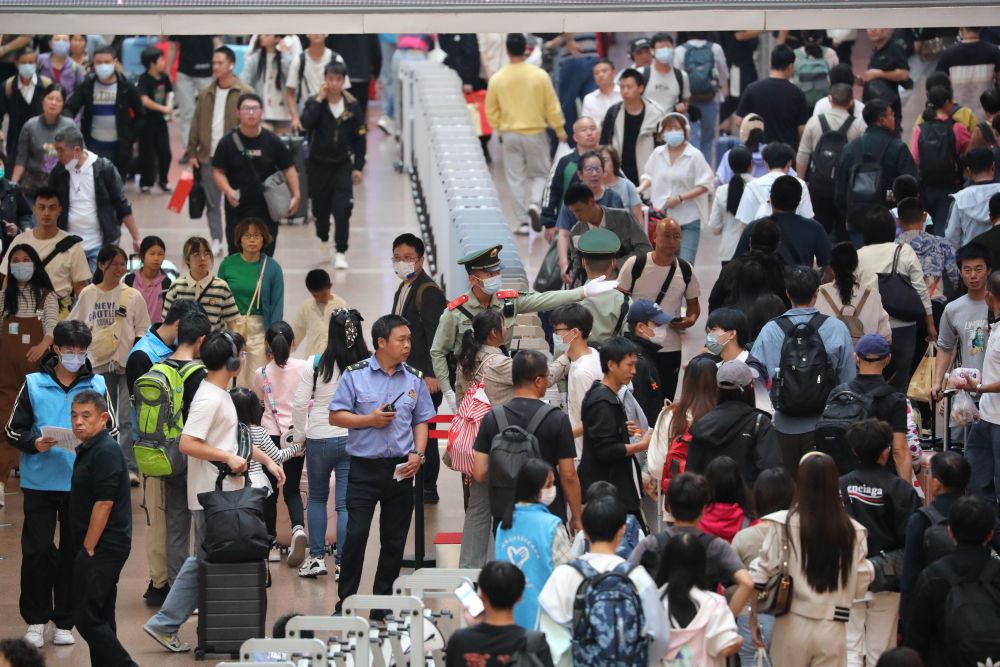 武警北京总队执勤第六支队官兵在北京西站候车厅为国庆假期出行的旅客指路(9月30日摄)。新华社发(陈春越 摄)