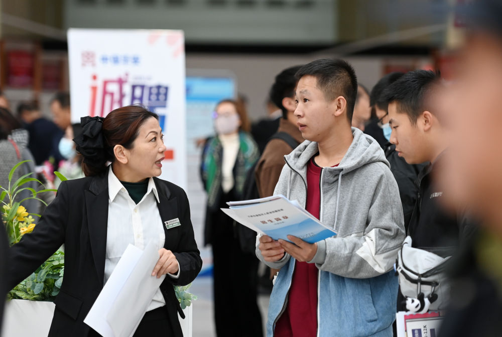 2023年11月10日,天津,求职者在招聘会现场与用人单位交流。新华社记者 赵子硕 摄
