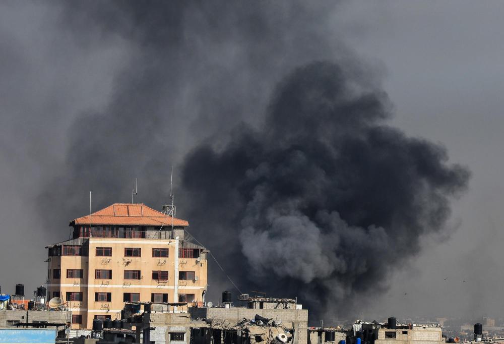 1月21日，加沙地带南部城市汗尤尼斯在遭遇以军空袭后升起浓烟。新华社发（亚西尔·库迪摄）