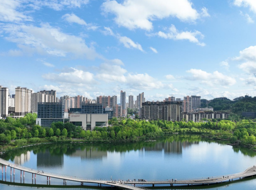 2024年5月4日,人们在贵州省遵义市新蒲新区天鹅湖湿地公园的廊桥上