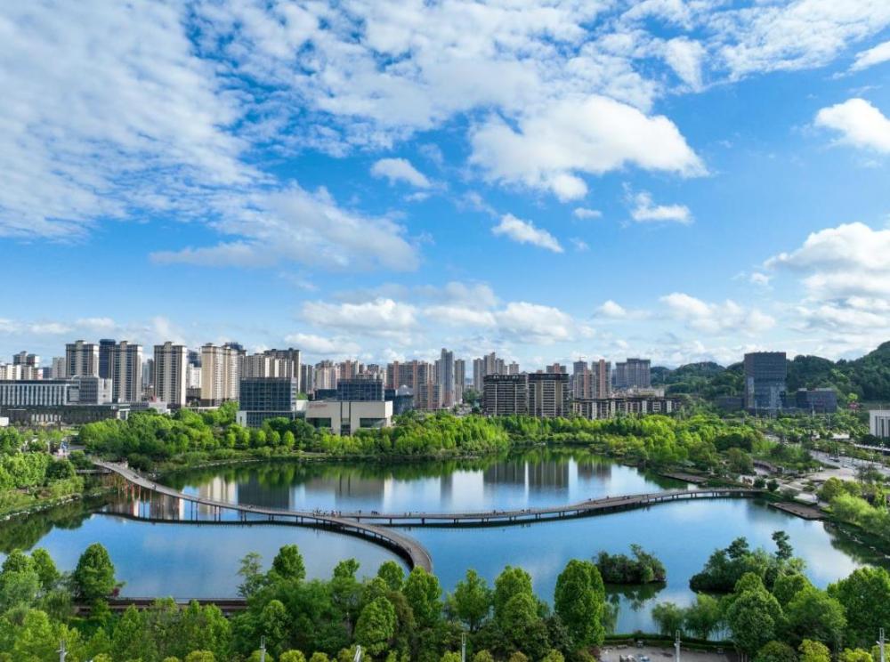 2024年5月4日,人们在贵州省遵义市新蒲新区天鹅湖湿地公园的廊桥上