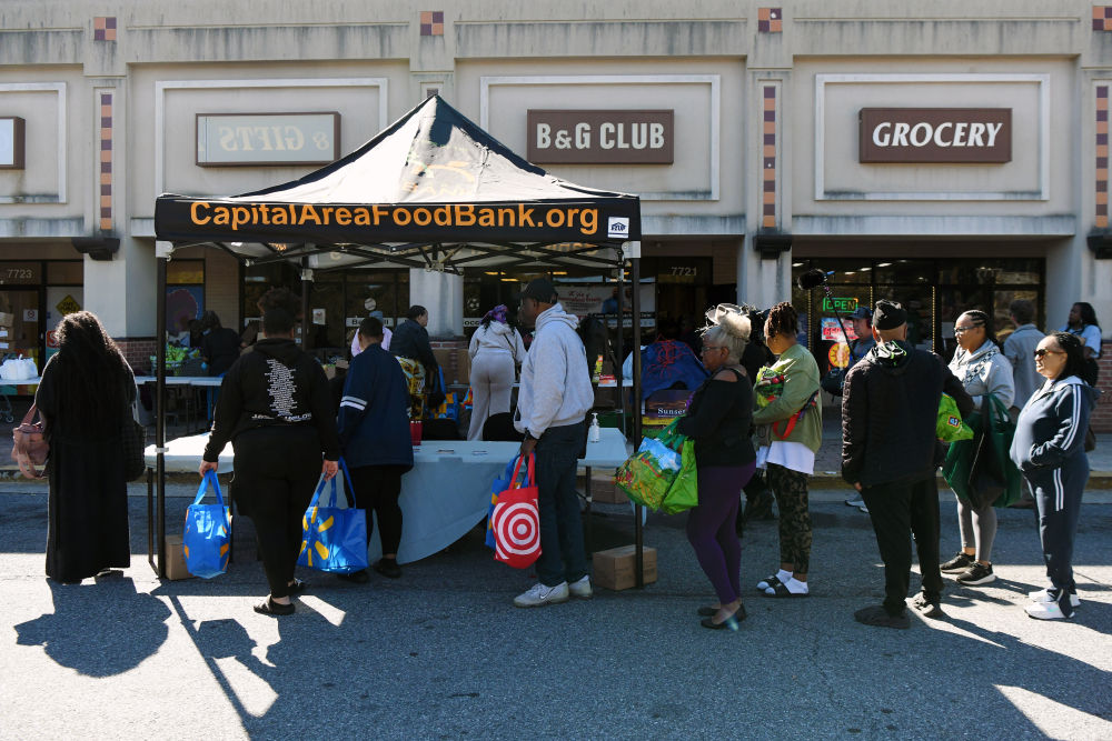 10月21日，在美国马里兰州海厄茨维尔市，联邦雇员排队登记领取免费食品。新华社记者李睿摄