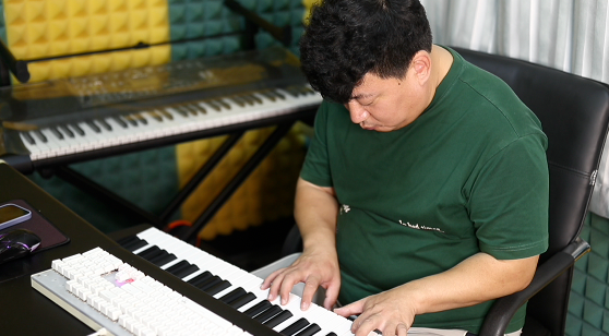 李广洲在工作室里弹琴。新华社发