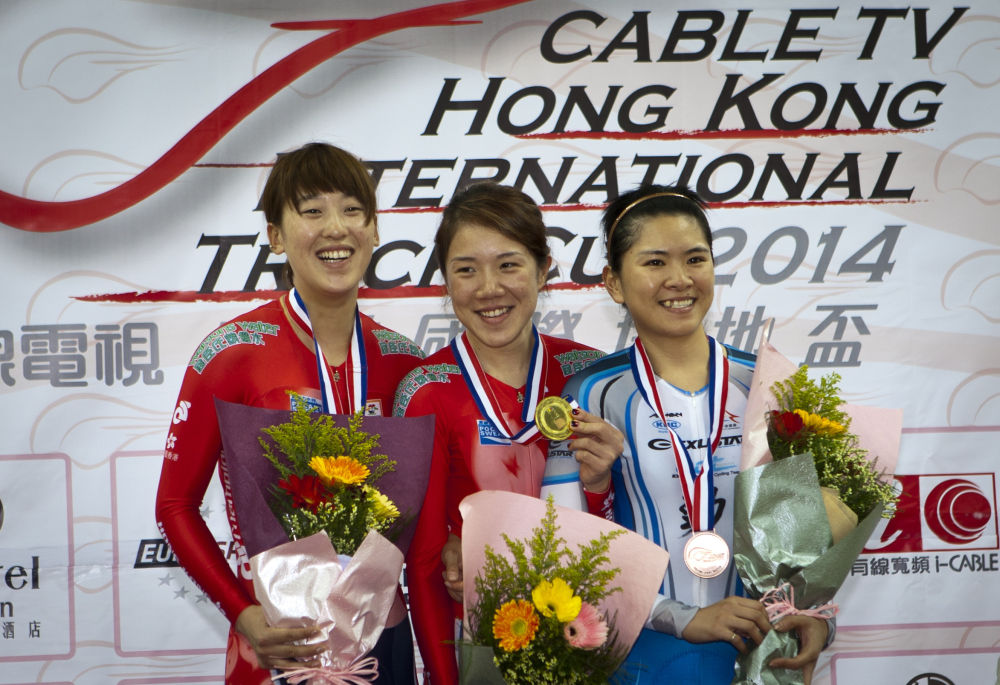 资料图：2014年1月11日，在香港将军澳自行车馆举行的国际场地杯自行车赛女子精英个人追逐赛中，香港选手包揽冠亚军。图为香港车手黄蕴瑶（中）和杨倩玉（左）在颁奖仪式上。新华社记者 何靖嘉摄