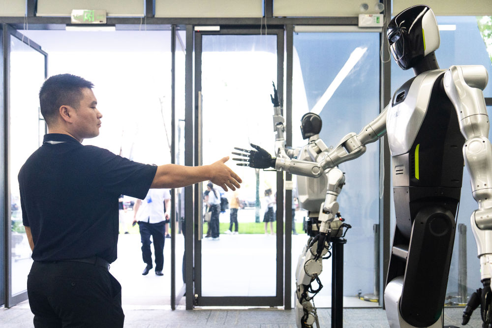 9月15日，在湖南湘江新区长沙智谷举办的2025互联网岳麓大会上，观众与一款中联重科研发的人形机器人握手。新华社记者 陈思汗 摄