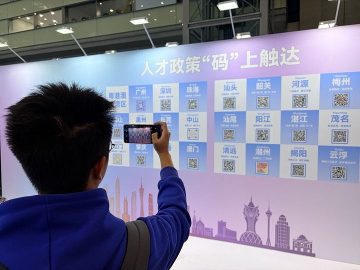 12月27日，求职者在招聘会现场扫码了解广东各市人才政策。新华社记者 赵瑞希 摄