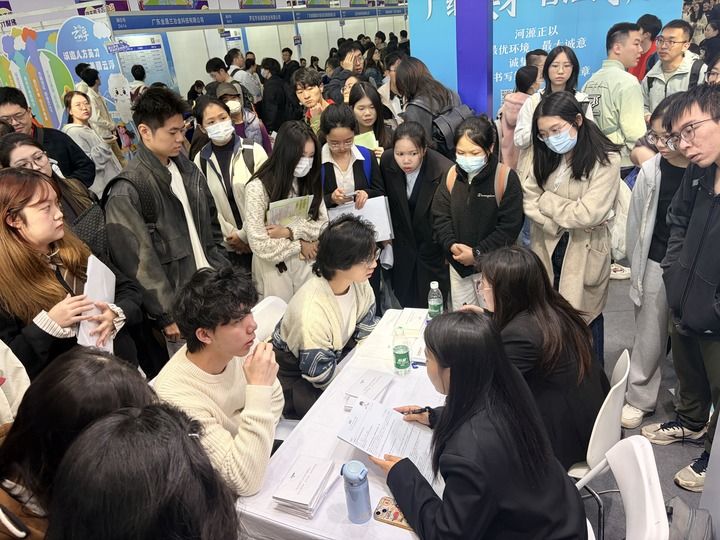 12月27日，在招聘会现场，求职者与企业招聘人员交流。新华社记者 赵瑞希 摄