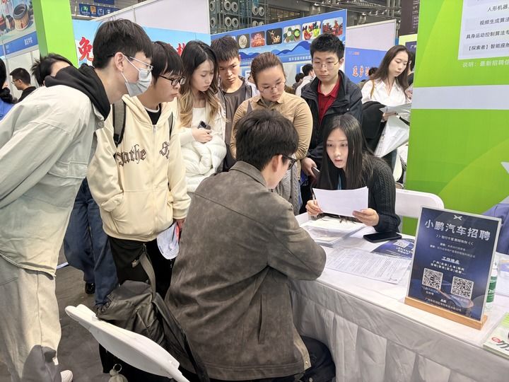 12月27日，在招聘会现场，求职者与企业招聘人员交流。新华社记者 赵瑞希 摄