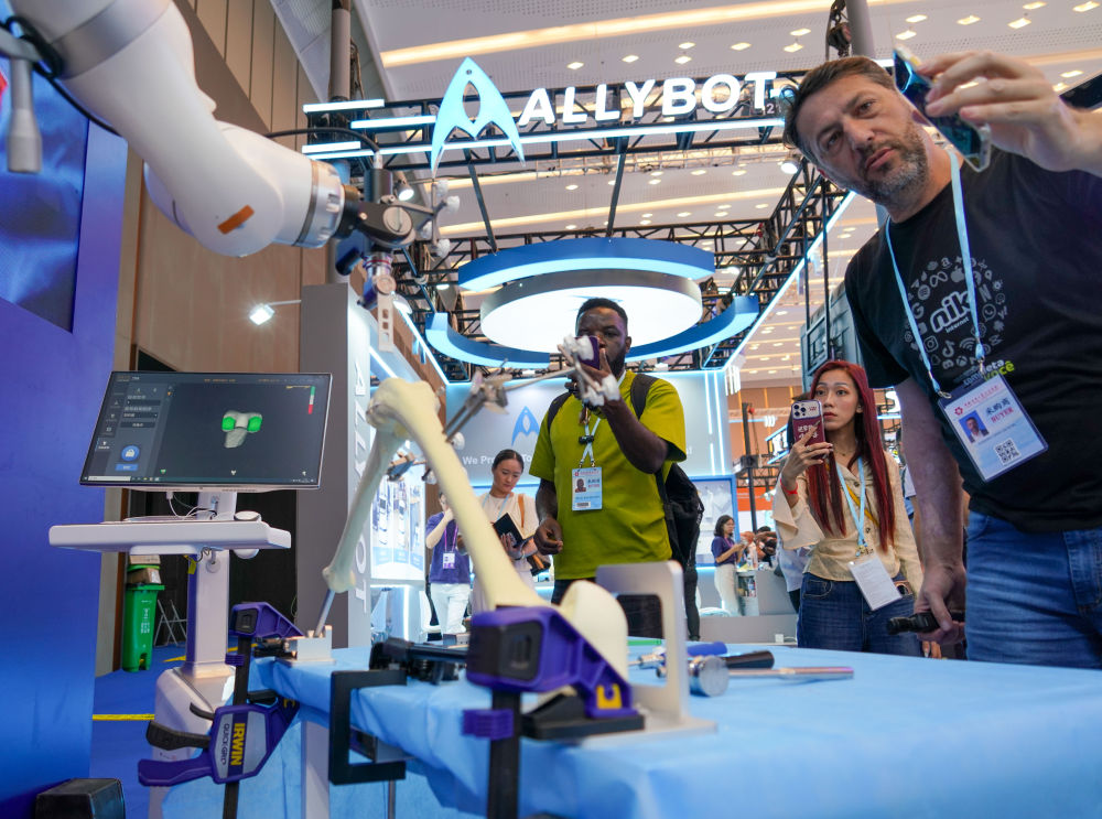 　　2025年10月16日，采购商在第138届广交会元化智能科技（深圳）有限公司展台观看手术机器人产品。（肖恩楠 摄）