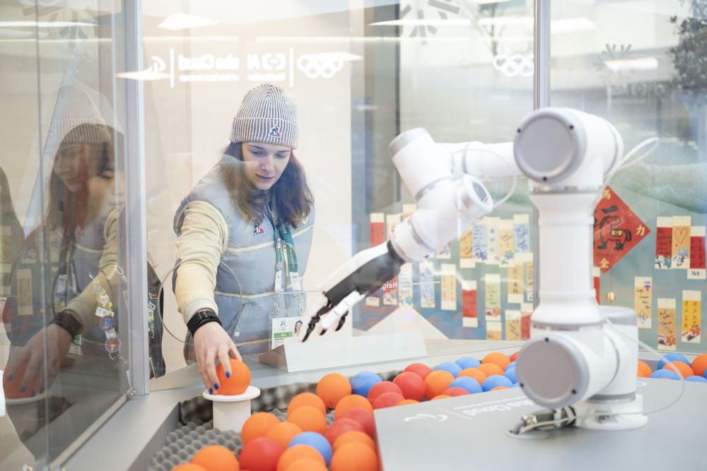 2月3日，法国冰球队运动员在赞助商阿里云展台体验智能徽章交换。新华社记者 张豪夫 摄