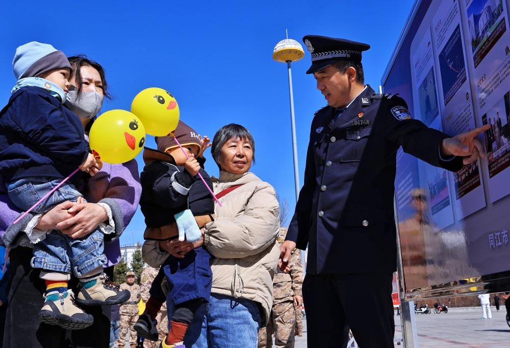 　　↑ 4月15日，在黑龙江省同江市，民警在向群众讲解国家安全知识。新华社发（刘万平摄）