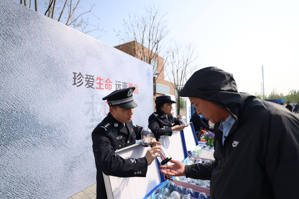 　　↑ 4月15日，在天津大学北洋园校区，民警为观众科普禁毒知识。新华社记者 孙凡越 摄