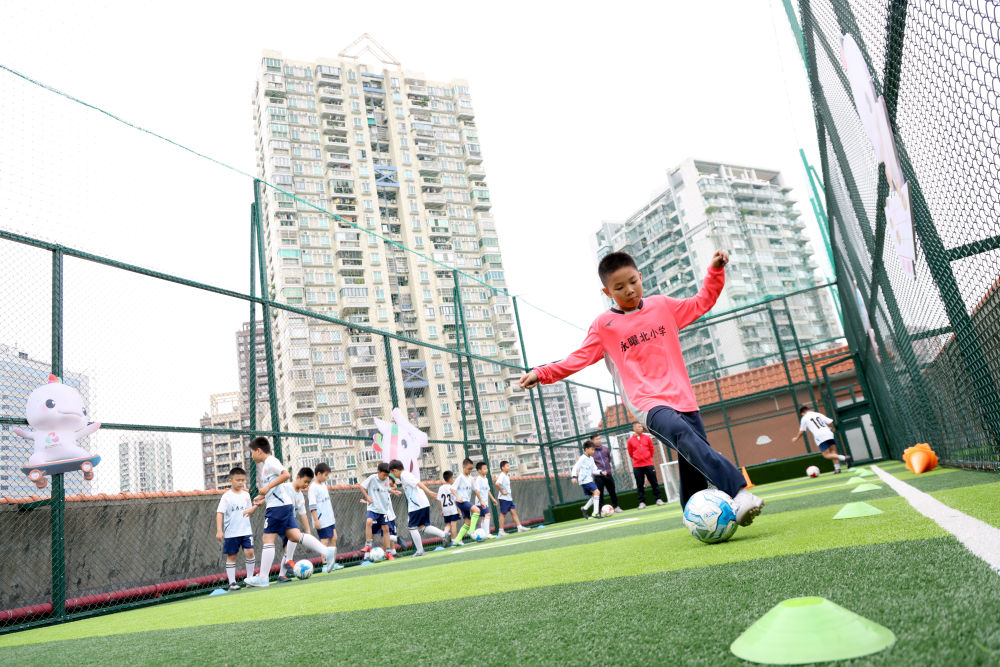 图为广州市永曜北小学的学生在学校楼顶天台的足球场踢球。新华社记者 卢汉欣 摄