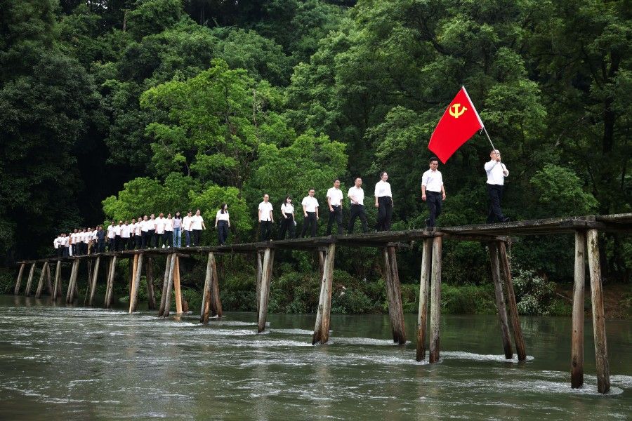 2026年7月1日,贵州省黔东南苗族侗族自治州黎平县高屯街道参加“重走长征路”活动的干部职工从修整后的红军桥上经过。新华社记者 杨文斌 摄